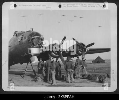 ANGLETERRE-après avoir bombardé Berlin, la capitale de la machine de guerre allemande, Boeing B-17 Flying Ofretresses of the US 8th Air Force circle à leur base en Angleterre, en préparation à l'atterrissage, alors que sur le terrain l'équipage de l'un des oprts qui traque Banque D'Images