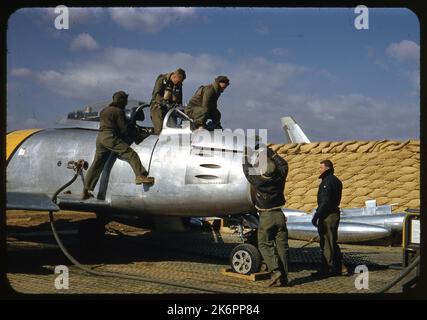 Vue du côté droit d'un F-86 Sabre nord-américain. Un technicien observe que le pilote monte hors du poste de pilotage, tandis que deux autres retirent le panneau avant supérieur du fuselage. Un quatrième technicien se trouve également à côté de l'avion. Vue du côté droit d'un F-86 Sabre nord-américain. Un technicien observe que le pilote monte hors du poste de pilotage, tandis que deux autres retirent le panneau avant supérieur du fuselage. Un quatrième technicien se trouve également à côté de l'avion. Banque D'Images