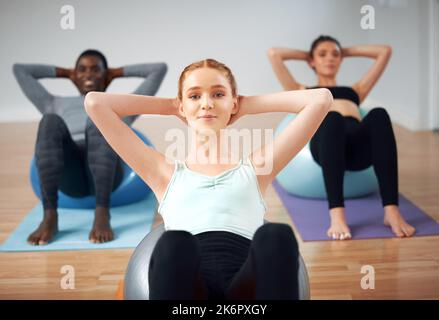 Je ne suis jamais fier de mes progrès. groupe d'étudiants effectuant des croquchs pendant un cours de pilates. Banque D'Images