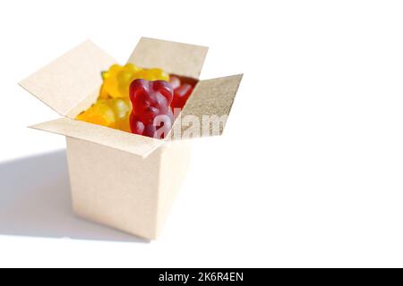 Boîte de livraison miniature pleine d'ours en gelée colorés isolés sur fond blanc avec espace de copie. Acheter des bonbons en ligne. Banque D'Images