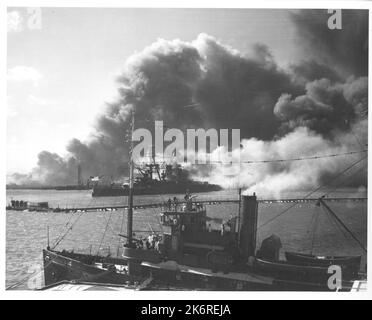 Photographie de l'USS Nevada après l'attaque japonaise sur Pearl HarborLe USS Nevada (BB36) après l'attaque japonaise sur Pearl Harbor, décembre 7 1941. Déplacement à l'écart des navires enflés. Le premier plan de sauvetage et de sauvetage remords les équipes d'armes à feu en action. Banque D'Images