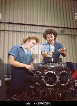 'Two WAVES, Elaine Olsen, SN2/c, (à gauche) USN, et Ted Snow, SN2/c, USN, apprendre à retirer le bloc moteur de l'avion pendant l'entraînement à NAS, Lakehurst, N.J.' Légende sur la manche négative : « WAVES LEARN MECHANICS - Bonde Elaine Olsen, Seaman 2c, de Chicago, et brunette Ted Snow, Seaman 2c, de Saginaw, Michigan, apprennent à faire tomber un bloc moteur d'avion pendant leur entraînement à la base aérienne américaine de Lakehurst. » Banque D'Images