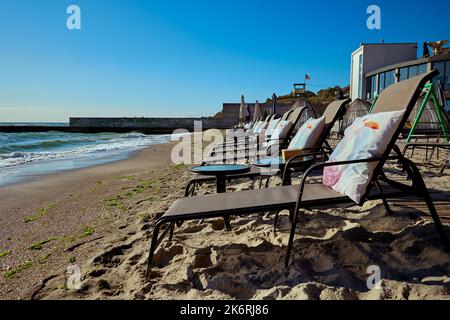 Chaises de plage avec coussins et tables au bord de la mer surf sur une matinée ensoleillée Banque D'Images