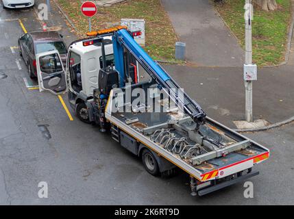 Chariot de remorquage avec grue et plate-forme vide prêt à transporter un véhicule stationné illégalement Banque D'Images