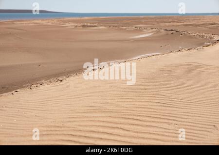 Ondulations dans le sable fait par le vent. Texture des dunes déplacées par le vent. Paysage tropical. Banque D'Images