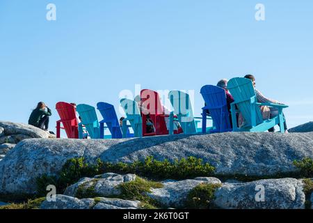 Peggys Cove, Nouvelle-Écosse, Canada -- 17 septembre 2022. Les touristes s'assoient dans des chaises hautes en couleurs à Peggys Cove. Banque D'Images