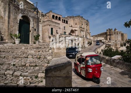 Un véhicule touristique rouge de style ancien sur les rues des pierres de Matera Banque D'Images