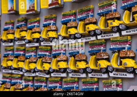 Des rangées de petites vespa jaune miniature comme souvenirs dans une boutique touristique de Matera Banque D'Images