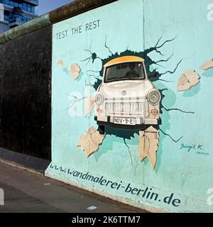 Murale sur le reste du mur de Berlin avec l'épreuve de stress cardiaque (Test du reste), Trabi durchbricht Mauer, artiste Birgit Kinder, East Side Gallery Banque D'Images