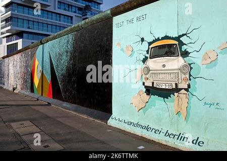 Murale sur le reste du mur de Berlin avec l'épreuve de stress cardiaque (Test du reste), Trabi durchbricht Mauer, artiste Birgit Kinder, East Side Gallery Banque D'Images