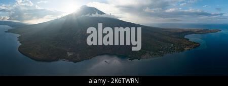 Le soir, la lumière du soleil se dégage autour du volcan actif d'Iliape dans les îles de la petite Sunda en Indonésie. Ce stratovolcan se trouve entre Flores et Alor. Banque D'Images