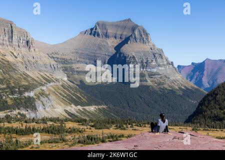 Parc national des Glaciers, Montana États-Unis - 26 septembre 2022 : randonneur profitant de la vue à couper le souffle depuis le sentier du lac caché au sommet du col de Logan Banque D'Images