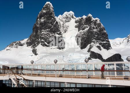 bateau de croisière passant devant des tours de roche de basalte à calotte glaciaire, faisant partie des sommets humphries, à cape renard, à l'entrée nord du canal lemaire (kodak gap, kodak a Banque D'Images