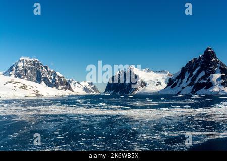 glace à brises flottant sur les eaux de l'approche nord du canal de lemaire (kodak gap, kodak alley) avec stand island et mt. lacroix à droite et humphries Banque D'Images