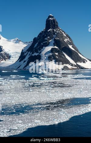 glace à brises flottant sur les eaux de l'approche nord du canal de lemaire (kodak gap, kodak alley) avec stand island et mt. lacroix en arrière-plan. wilhelm Banque D'Images