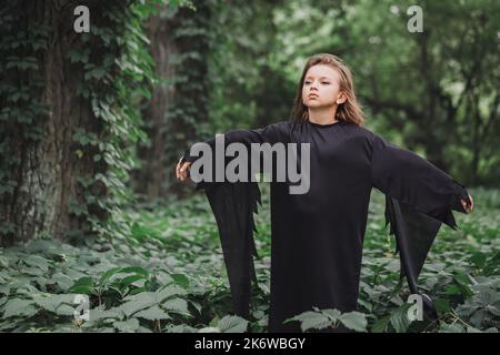 Portrait d'une charmante jeune sorcière dans la forêt. Concept Halloween Banque D'Images