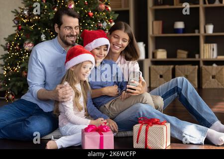 Joyeux deux enfants et parents parlant sur appel vidéo Banque D'Images