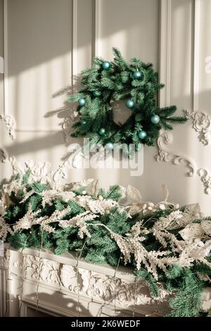 Décorations pour la nouvelle année, une couronne de branches de sapin sur le mur. Couronne décorative de Noël dans une maison confortable Banque D'Images