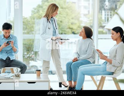 Quelqu'un vous l'a expliqué. un médecin mature et sa patiente discutent de ses derniers résultats dans la salle d'attente. Banque D'Images