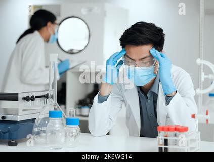 Je sens les murs se fermer. un jeune scientifique regardant stressé avec un mal de tête. Banque D'Images