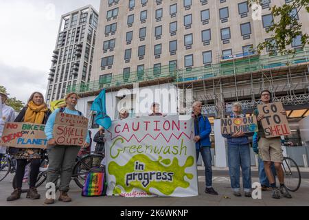 Londres, Royaume-Uni. 15 octobre 2022. Un groupe d’activistes climatiques organise une manifestation devant un bâtiment en rénovation à Londres, s’opposant aux prétendus investissements de Shell en faveur du greenwash et des combustibles fossiles. Les manifestants tiennent des pancartes indiquant « PAS D’EMPLOIS SUR Une PLANÈTE MORTE », « ATTENTION : greenwash in Progress » et « GO TO SHELL », soulignant les préoccupations concernant les revendications de durabilité des entreprises et l’impact environnemental. Des activistes de Fossil Free London organisent une petite manifestation devant le siège londonien de Shell contre le parrainage de British Cycling par la société. Penelope Barritt/Alamy Live News Banque D'Images