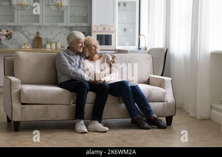 Un couple plus âgé rêve de se détendre ensemble sur un canapé Banque D'Images