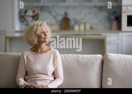 Belle femme blonde d'âge moyen, attentionnés, regardant au loin Banque D'Images