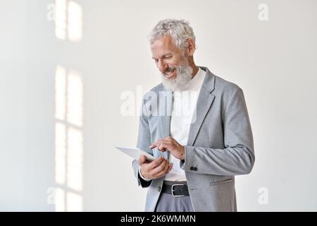 Un vieil homme d'affaires heureux utilisant une tablette isolée sur fond blanc. Banque D'Images