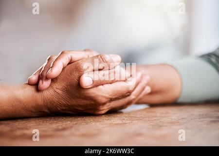 Tenez fermement le tout foncé. un couple senior méconnaissable se tenant les mains et se réconfortant les uns les autres à la maison. Banque D'Images