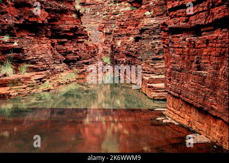 Les murs de roche rouge de la gorge Hancock de Karijini se reflètent dans un trou d'eau Banque D'Images