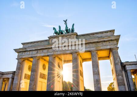 La célèbre porte de Brandebourg à Berlin avec le dernier soleil se raye avant le coucher du soleil Banque D'Images