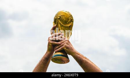 12 juin 2018, Doha, Qatar, Un homme tient la coupe du monde de la FIFA entre ses mains. Banque D'Images