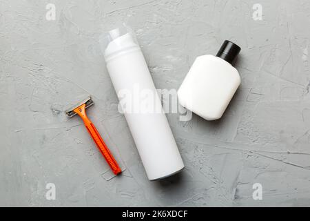 kit homme à raser. machine à raser, serviette, lotion et mousse à raser sur fond coloré. Articles de bain pour hommes vue du dessus. Banque D'Images