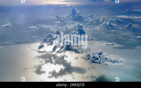 Prise de vue aérienne de l'eau de mer reflétait les lumières chaudes du coucher du soleil, le paysage nuageux dans le ciel jetant leur ombre sur l'océan, paisible scène du ciel en soirée Banque D'Images