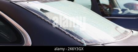 Vitre arrière cassée d'une voiture noire dans la rue, gros plan Banque D'Images