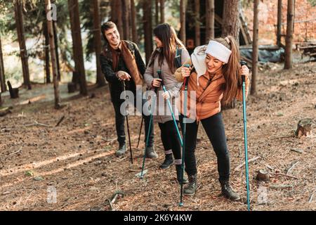 Des amis grimpant sur la colline ensemble, riant et s'amusant. Couleurs d'automne Banque D'Images