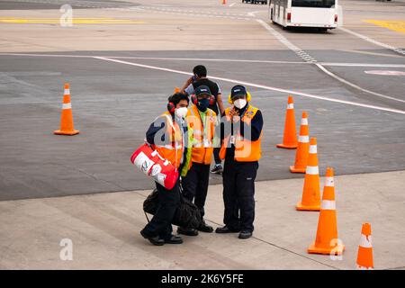 Lima, Pérou - 27 juillet 2022: Les hommes latins portant un masque et une veste d'orange comme les Cones Banque D'Images