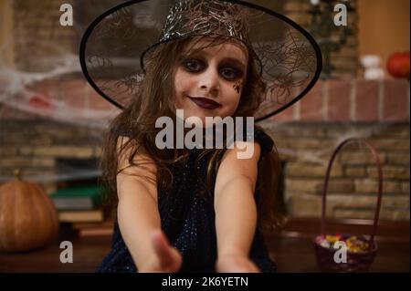 Belle petite fille à la recherche d'une sorcière, dans un chapeau de magicien, prêt pour la fête d'Halloween. Style gothique. Festival d'automne Banque D'Images