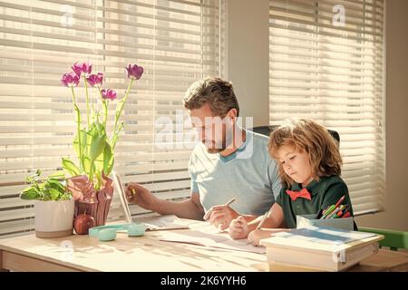 papa barbu écrivant des devoirs à l'école avec son fils garçon en classe, jour de la famille Banque D'Images