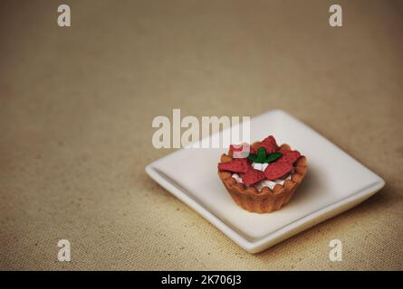 Tartelette aux fraises modèle alimentaire encore la vie sur une plaque blanche Banque D'Images