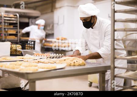 Boulanger masculin travaillant avec des baguettes formant de la pâte Banque D'Images