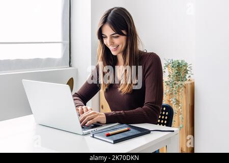 Jeune femme d'affaires adulte confiante travaillant sur un ordinateur portable au bureau à domicile Banque D'Images