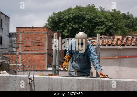 Travailleur portant un masque de soudeur sur la construction de la nouvelle route Banque D'Images