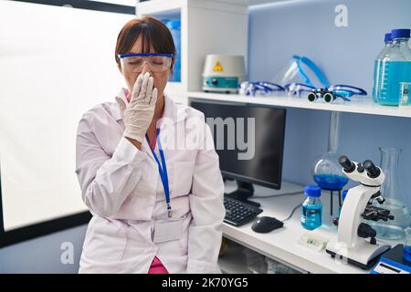 La jeune femme brunette travaillant au laboratoire scientifique s'ennuyait bâilling fatiguée couvrant la bouche avec la main. agité et somnolence. Banque D'Images