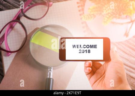 Concept d'affaires : BIENVENUE 2018 MOTS SUR smartphone avec arrière-plan de table de bureau Banque D'Images