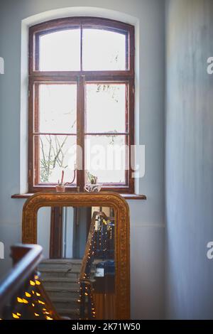 L'escalier dans le bâtiment à Noël dans une guirlande lumineuse monte jusqu'au miroir. Photo verticale. Banque D'Images