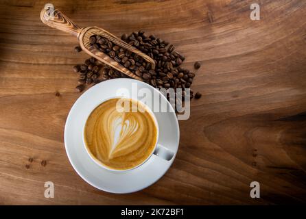 Grains de café rôtis au cappuccino au design en mousse Heartbeat Banque D'Images