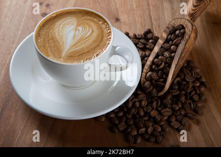 Grains de café rôtis au cappuccino au design en mousse Heartbeat Banque D'Images