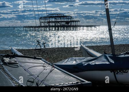 Plusieurs petits bateaux en premier plan sur le front de mer de Brighton avec la mer et le West Pier en arrière-plan Banque D'Images