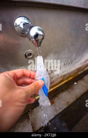 Lourdes, France. 2 septembre 2022. Un pèlerin remplit une bouteille en forme de Vierge Marie avec le printemps de l'eau Sainte de Lourdes Banque D'Images